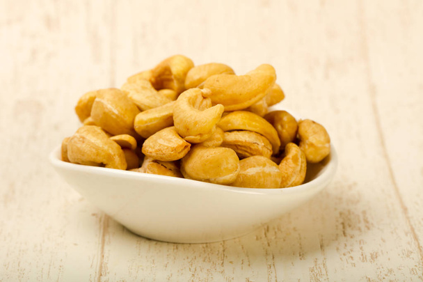 Cashew nuts heap over wooden background - Valokuva, kuva