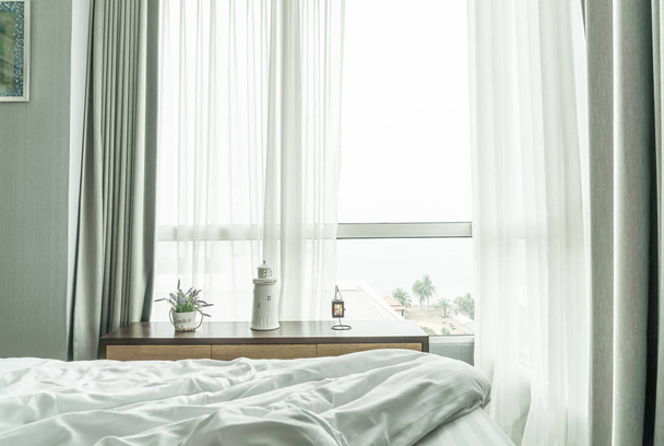 messy bed with curtain and window (view from bed) - Foto, imagen