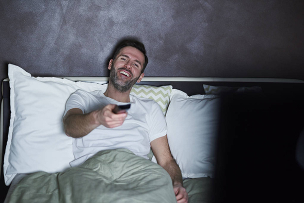 Счастливый человек смотрит телевизор по вечерам
  - Фото, изображение