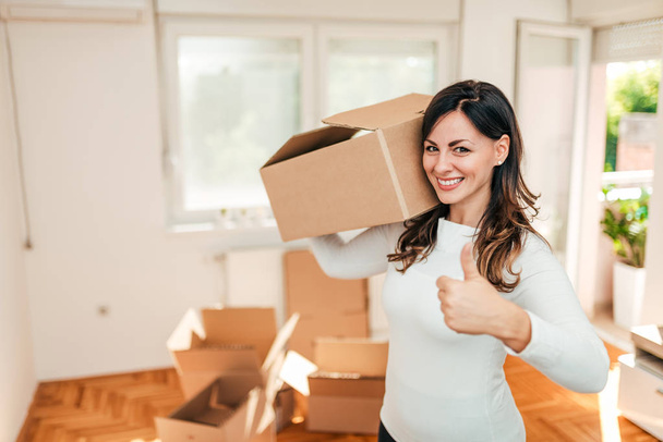 Happy young woman moving to a new home. - Foto, Imagem