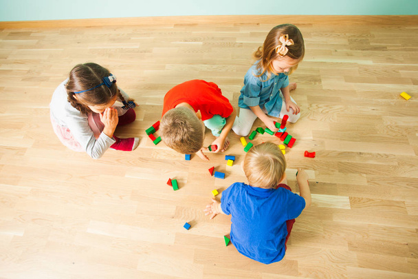 Top view of group of children playing on a floor - Фото, изображение