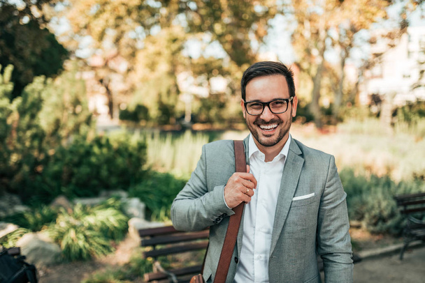 Portrait of a modern business man outdoors. Smiling and looking at camera. - Foto, imagen