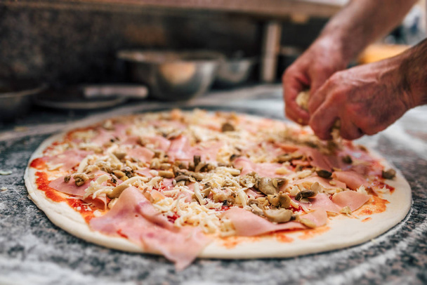 Delicious pizza preparation at kitchen - Foto, Bild