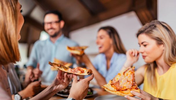 Close-up image of friends eating pizza. - Photo, Image