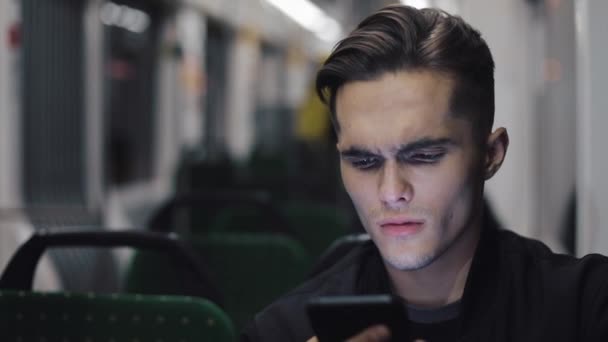 Unhappy young businessman with smartphone reading bad news riding in public transport - Séquence, vidéo