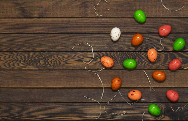 Huevo de Pascua colorido en el nido sobre fondo de madera. Vista superior con espacio de copia
 - Foto, imagen