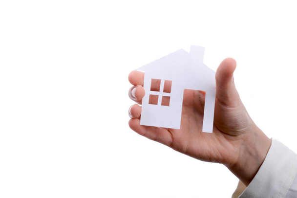 Hand holding an isolated paper house with a white background - Photo, Image