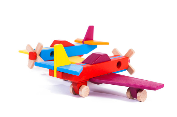 Foto von zwei hölzernen mehrfarbigen Flugzeugen aus Buche. Spielzeug Holz Retro-Flugzeuge auf weißem Hintergrund isoliert - Foto, Bild