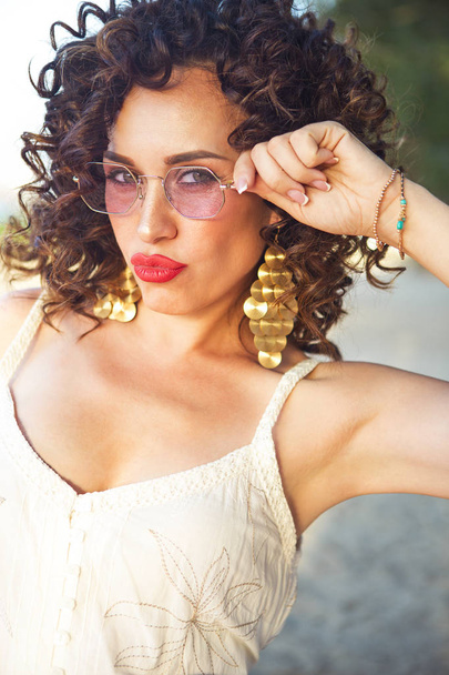 Fête fille au festival d'été portant des lunettes de soleil roses et des boucles d'oreilles dorées
 - Photo, image