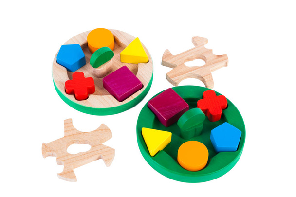 Fotografie dřevěné hračky dětské třídičky s malými dřevěnými detaily v podobě geometrických tvarů (obdélník, čtverec, kruh, trojúhelník), v různých barvách na bílém izolovaném pozadí - Fotografie, Obrázek
