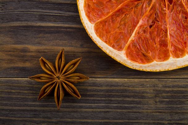 dried grapefruit and anise stars on wooden background - Foto, imagen