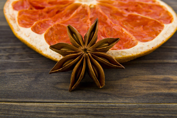dried grapefruit and anise stars on wooden background - Foto, immagini