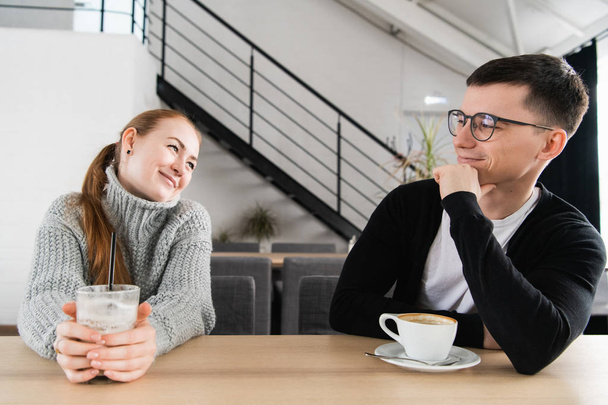Candid image of young couple smiling in a coffee shop - Zdjęcie, obraz