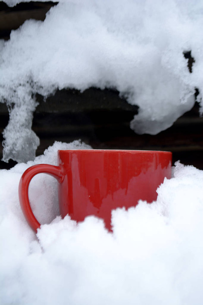 Red mug with tea in the snow Winter morning Copy space - Foto, imagen