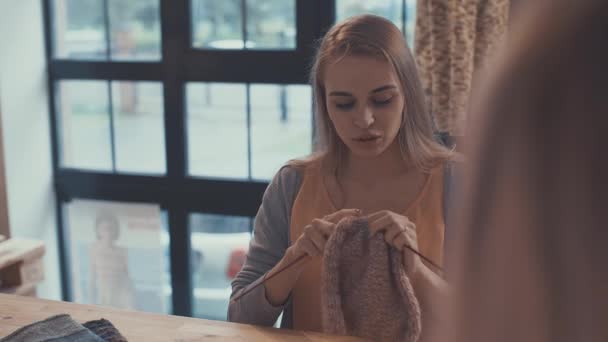 Young girl knitting in studio - Materiał filmowy, wideo