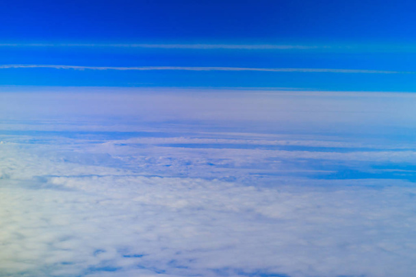 Όμορφα άσπρα σύννεφα στον γαλάζιο ουρανό. Θέα από αεροπλάνο - Φωτογραφία, εικόνα