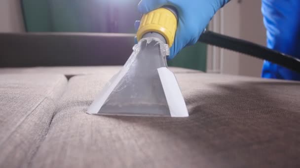 Käsite siivous asunnossa ja toimistossa. Kuivapesulatyöntekijä poistaa likaa sohvalta sisätiloissa
 - Materiaali, video