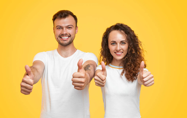 Cheerful couple gesturing thumb up - Foto, imagen
