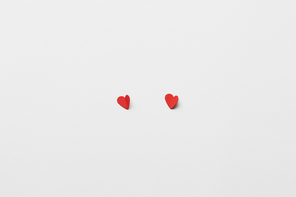top view of two red paper cut hearts on white background - Foto, imagen