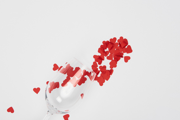 top view of wine glass and heap of red paper cut hearts isolated on white - Photo, image