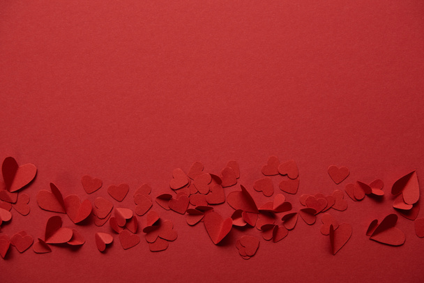 pile of decorative paper cut hearts on red background with copy space - Foto, Imagem