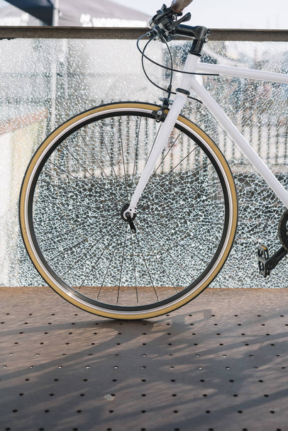 Şehir bisiklet dişli kırık cam duvara sabit. - Fotoğraf, Görsel