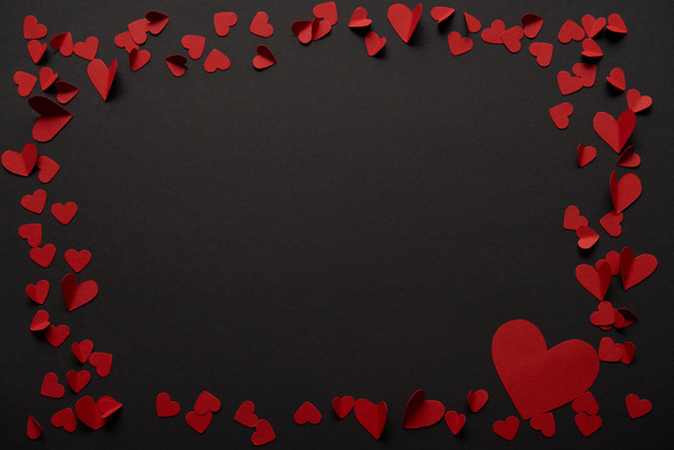 fekete háttér másol hely és papír vágott piros szívek  - Fotó, kép