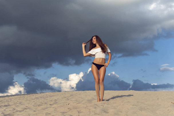 Walk with a brunette on the hot sand - Fotoğraf, Görsel