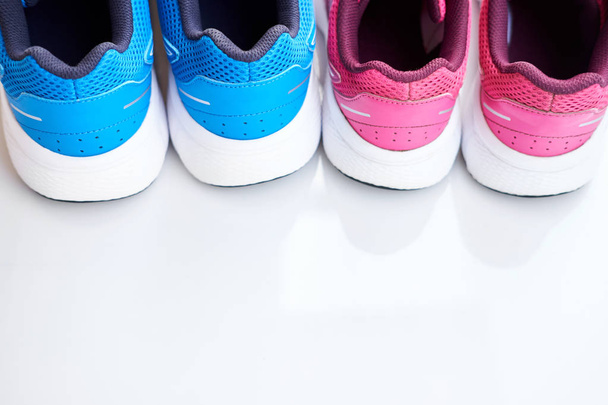 Coppia di sneakers da corsa blu per uomo e coppia di scarpe rosa per donna su sfondo bianco. Concetto amore correre. Correte insieme. A conduzione familiare. Vista dall'alto. Copia spazio
.  - Foto, immagini