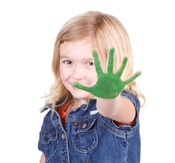 een kind met groene verf op haar hand - Foto, afbeelding