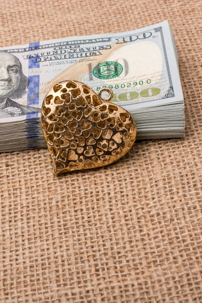corazón icono paquete de dólar estadounidense colocado en un lienzo de lino - Foto, Imagen