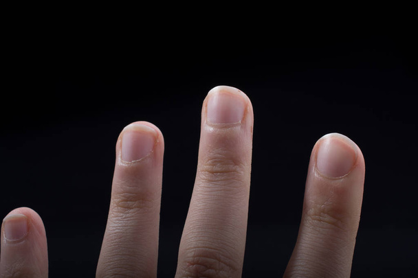 Cuatro dedos de una mano infantil parcialmente vistos en fondo negro - Foto, imagen