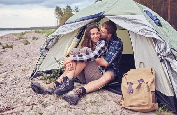Couple camping. Young people sitting in tent watching the view - Photo, Image
