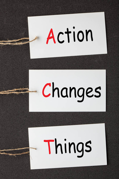 Action Changes Things (ACT) acronym written on paper labels set on black background. Business concept - Photo, Image