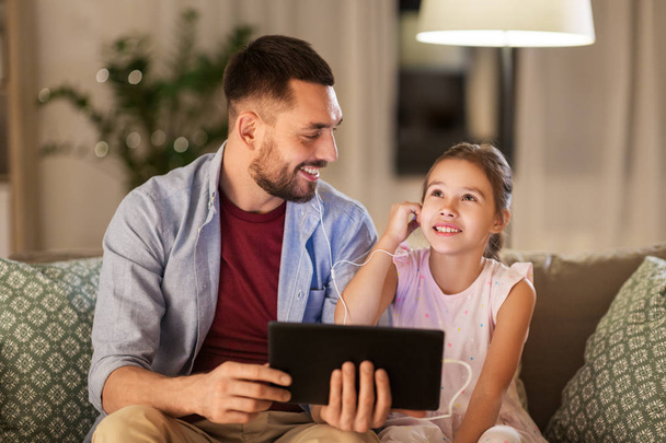 father and daughter listening to music on tablet - Φωτογραφία, εικόνα