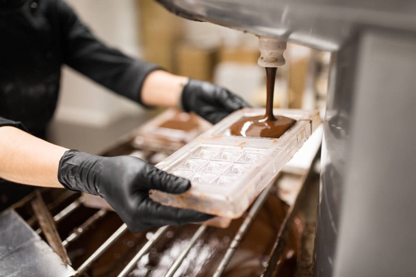 confectioner makes chocolate candies at sweet-shop - Foto, Imagen