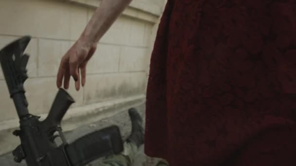 red head female vampire throwing weapon on dead soldier on street - Materiał filmowy, wideo