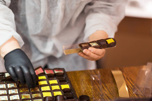 worker packing candies at confectionery shop - Foto, Imagen