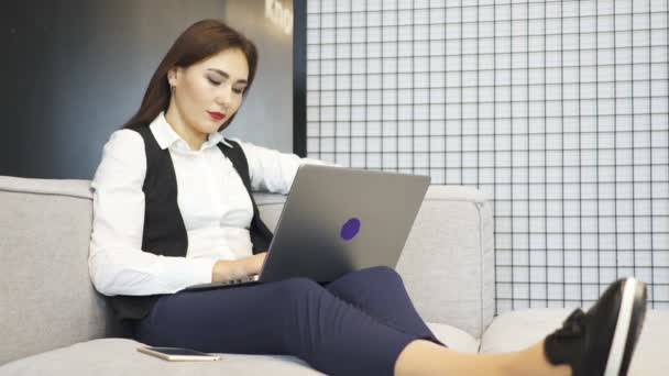 4. Asya güzel iş kadın kanepe üzerinde ofis işleri. Tip laptop - Video, Çekim