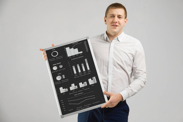 Предприниматель на белом фоне с магнитной доской с графиками и диаграммами
 - Фото, изображение