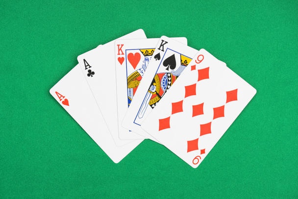 top view of green poker table with unfolded playing cards with different suits - Photo, Image