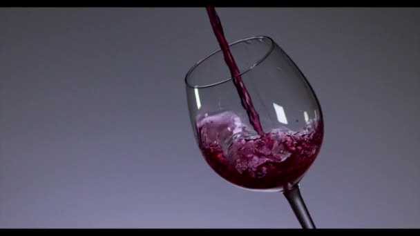 Kırmızı şarap şarap cam koyu arka plan üzerinde dökme. 4k, ağır çekim. - Video, Çekim