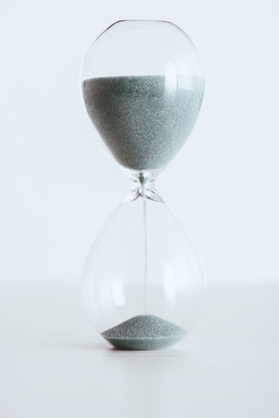 transparent hourglass with running sand isolated on white - Foto, immagini