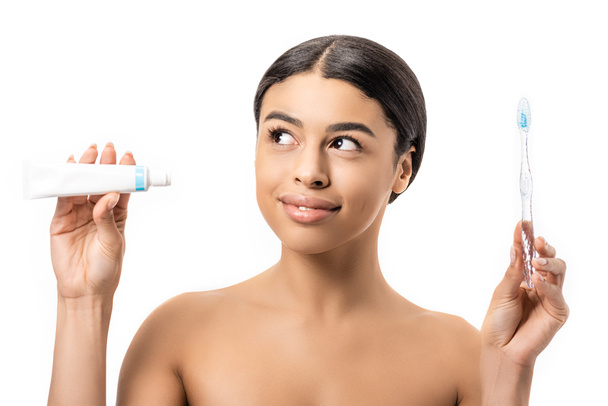 sorridente menina americana africana nua segurando pasta de dentes e escova de dentes isolado no branco
 - Foto, Imagem