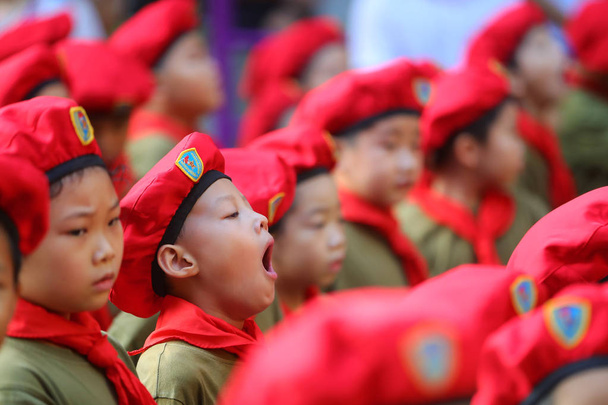 Un jeune élève bâille alors que lui et d'autres élèves assistent à une cérémonie de levée de drapeau d'un nouveau semestre dans une école primaire de la ville de Nanning, dans la région autonome du Guangxi Zhuang, en Chine du Sud, le 1er septembre 2017
. - Photo, image