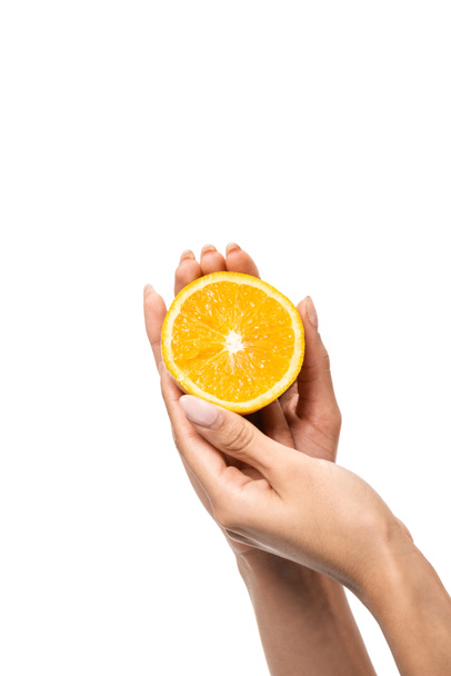 closeup partial view of african american woman holding slice of orange in hands isolated on white - Φωτογραφία, εικόνα