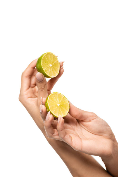 cropped shot of young african american woman holding halves of lime in hands isolated on white - Fotografie, Obrázek