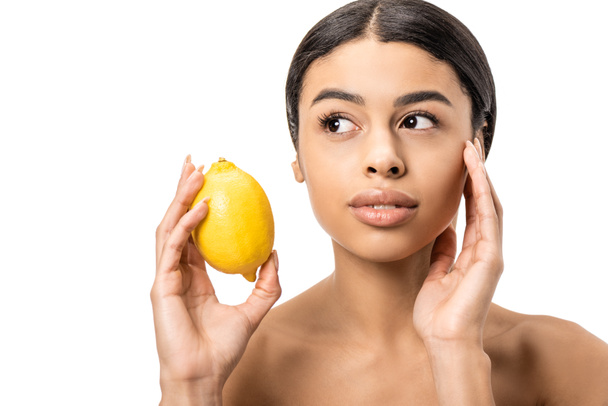 séduisante jeune femme afro-américaine tenant le citron frais et le visage touchant isolé sur blanc
 - Photo, image