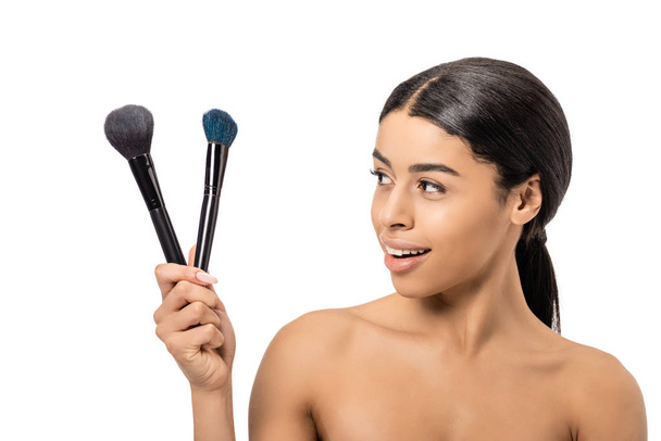 happy naked african american girl holding makeup brushes isolated on white - Photo, Image