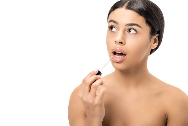 привлекательный голый африканский американец девушка применяя блеск для губ и глядя вверх изолированы на белом
 - Фото, изображение